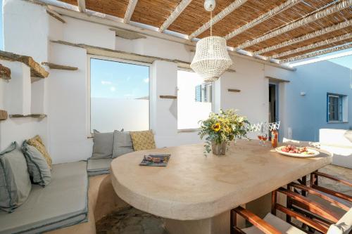 提诺斯Golden Beach Studios & Suites的一间厨房和带大木桌的客厅