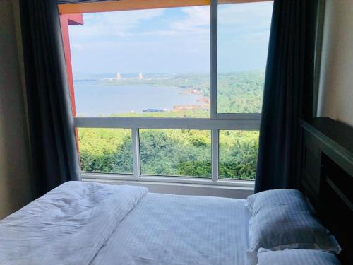 达波林lovely 2-bedroom sea view serviced apartment dabolim goa的一张位于带大窗户的房间内的床铺