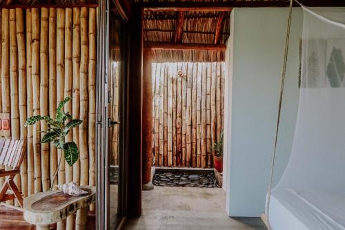 El TránsitoNimbu Beachhouse的一个带竹墙的门廊的房间