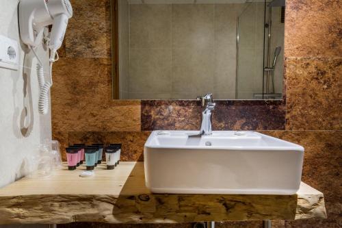 阿林萨尔Hotel Sant Gothard的一间带白色水槽和电话的浴室