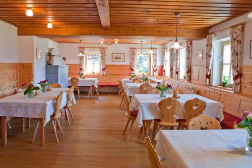 蒙圭尔福李哈尔特霍夫旅馆的一间设有白色桌子和木制天花板的用餐室