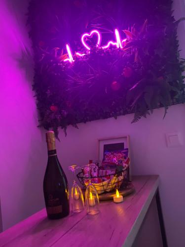贝桑松L’appart[é] BLACK superbe appartement pop !的一瓶葡萄酒坐在一张粉色光的桌子上