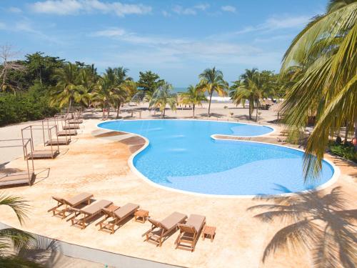 伯里塔卡Tay Beach Hotel Tayrona的一个带躺椅和沙滩椅的游泳池