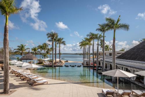 Beau Champ毛里求斯安娜希塔四季度假酒店的一个带游泳池、棕榈树和椅子的度假酒店
