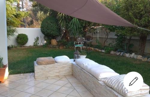 斯巴达Casa Martina 2 (Spata) 10min El.Venizelos airport.的庭院里设有一个带沙发和遮阳伞的庭院
