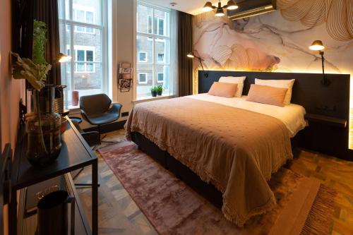 米德尔堡Boutiquehotel Princenjagt的一间卧室配有一张大床和一把椅子