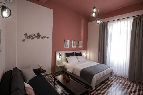 海若克利欧Elegant apartment in the heart of Heraklion的一间卧室配有一张床和一张沙发