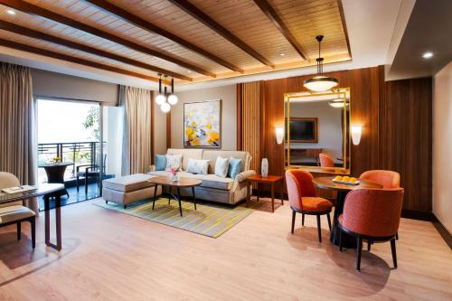 达兰萨拉Radisson Blu Resort Dharamshala的客厅配有沙发和桌子