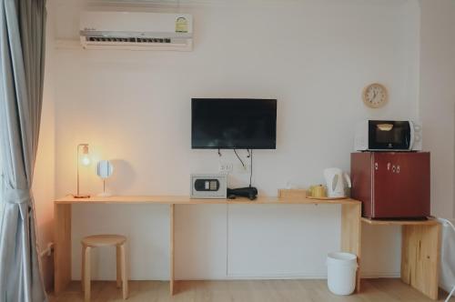 卡伦海滩锡拉之家公寓的客房设有一张桌子,墙上配有电视