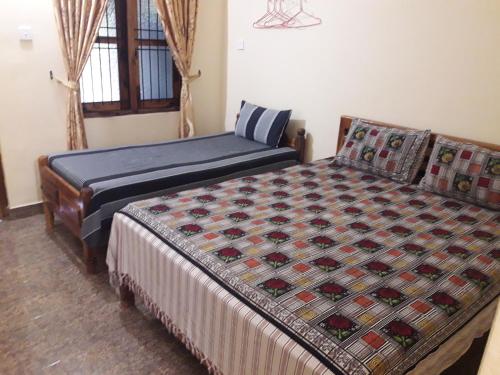 拜蒂克洛Naaval Beach Villa & Rooms的一间卧室设有两张床和窗户。