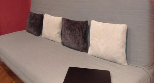 布达佩斯吉泽拉一室公寓酒店的一张白色的床,上面有三个枕头