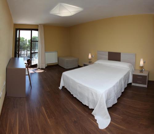 陶斯特Hotel Santuario de Sancho Abarca的卧室配有一张白色的大床,铺有木地板