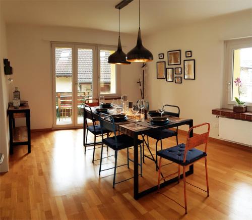 因特拉肯Interlaken City Apartments的一间用餐室,配有黑色的桌子和椅子