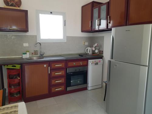 赫尔格达Hurghada Village sea view的厨房配有白色冰箱和木制橱柜。