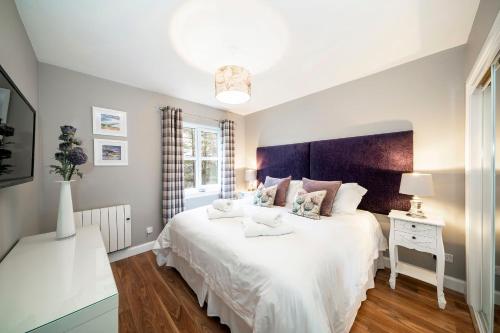 奥赫特拉德The Pines - Stunning 3 Bedroomed Apartment, Gleneagles的卧室设有一张白色大床和一扇窗户。