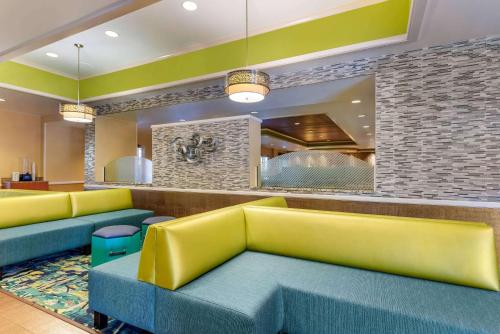 奥兰多Comfort Inn & Suites Near Universal Orlando Resort-Convention Ctr的一间设有黄色和蓝色沙发的等候室