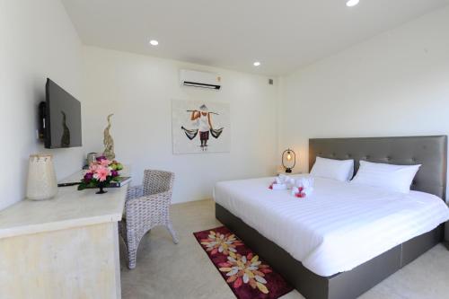 班佩Barong Resort的一间卧室配有一张床、一张书桌和一台电视