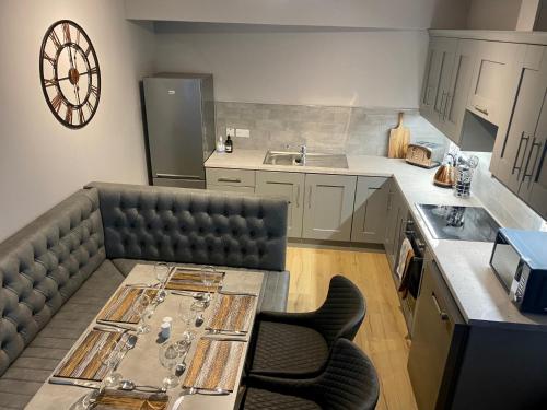 斯特拉班Dunlap Apartments的厨房配有沙发、桌子和时钟