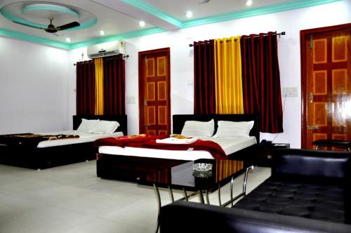 塔拉皮斯MADHU MAMATA HOTEL的配有两张床铺的带窗帘和椅子的房间