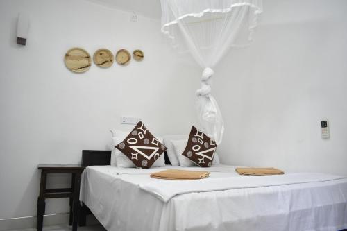 锡吉里亚斯吉利岩石边民宿的一张白色的床,上面有两个枕头