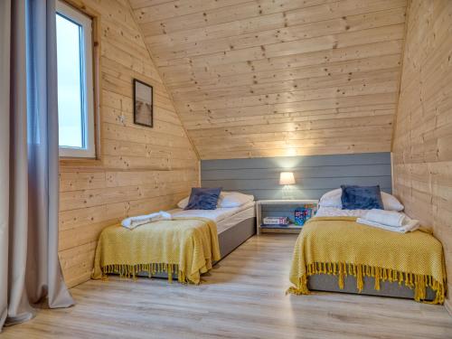 雅罗斯瓦维茨MikroKlimat的木墙客房的两张床