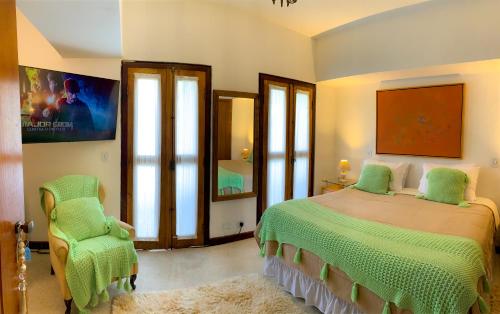 坎波斯杜若尔当Pousada Hortelã的一间卧室配有绿色的床和椅子