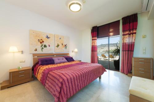 拉普拉亚蒂陶洛Sunset Villa的一间卧室设有一张床和一个大窗户