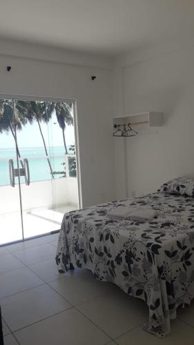 雅帕拉廷加Suíte em Japaratinga com Vista do Mar的一间卧室配有一张床,享有海景