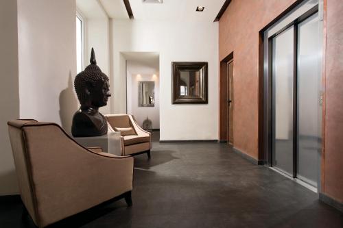 罗马罗马时代酒店的一间房间,里面设有椅子和雕像