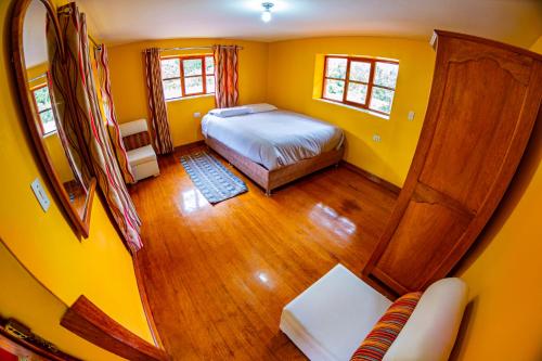 乌鲁班巴Happy Land Valle Sagrado的一间小卧室,配有床和黄色的墙壁