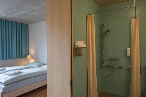 格施塔德格施塔德萨嫩兰德青年旅舍的客房内的1间带1张床和淋浴的浴室