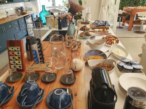 普利登堡湾Long Story Guest House的餐桌上放有盘子和碗的食物