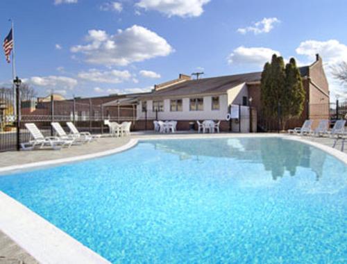 刘易斯堡Aderi Hotel Near Bucknell University的一个带椅子的大型蓝色游泳池