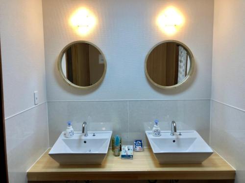 指宿市ゲストハウスまちかど Guest House MACHIKADO的浴室设有2个水槽和2个镜子