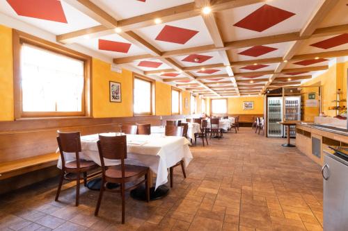 苏特廖Hotel Enzo Moro的一间在房间内配有桌椅的餐厅