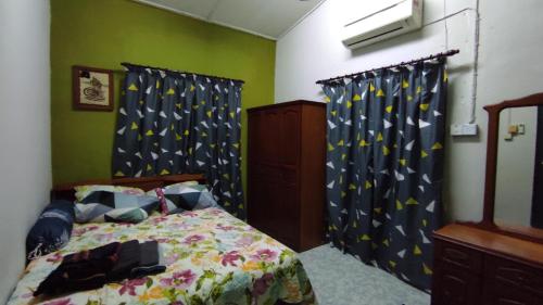巴力文打Homestay Opah Parit Buntar, Perak的一间卧室配有蓝色和黄色窗帘的床