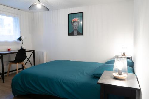 圣布里厄Bel appartement idéalement placé Saint-Brieuc, wifi, parking gratuit的一间卧室配有一张蓝色的床和一张带台灯的桌子
