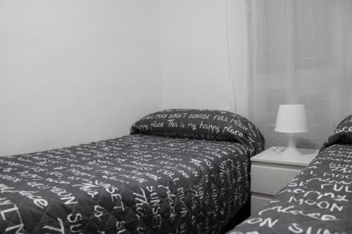 瓦伦西亚Casa chalet luxury emilia的一张带黑白棉被和灯的床