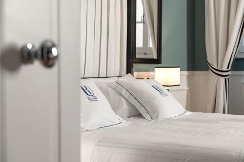 佛罗伦萨黎莱斯乌菲其酒店的一张白色的床,上面有两个枕头