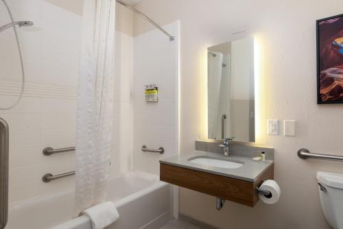 恩特普赖斯安特普锐斯烛木套房酒店的一间带水槽、浴缸和卫生间的浴室