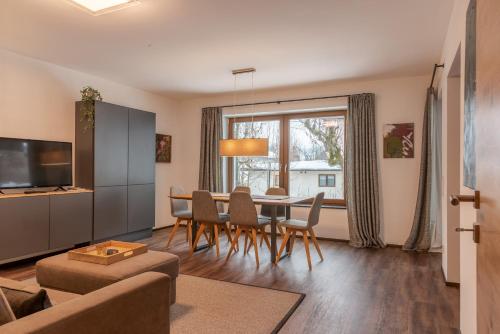 滨湖采尔Finest Villa Zell am See by All in One Apartments的客厅配有桌椅和沙发