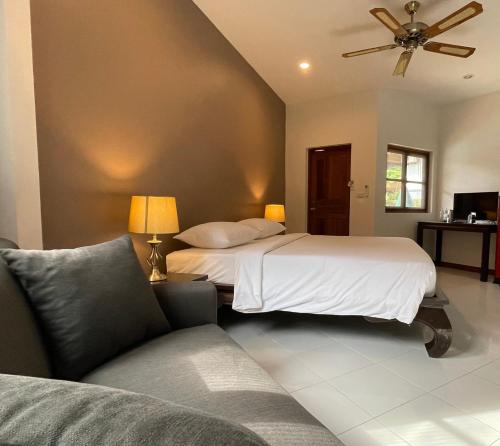 拉威海滩The Pace Phuket Boutique Resort的一间卧室配有一张床和一张沙发