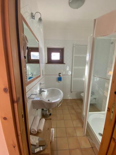 罗卡拉索Principessa Giovanna Boutique Chalet的浴室配有水槽、淋浴和浴缸。