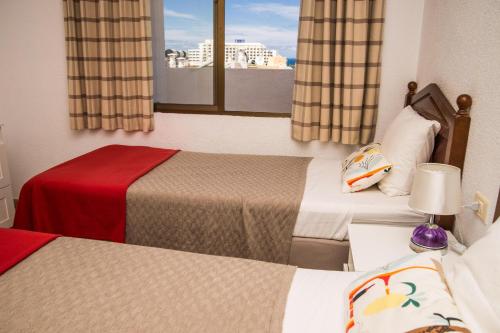 阿罗纳Best centric location for stay LA81的酒店客房设有两张床和窗户。