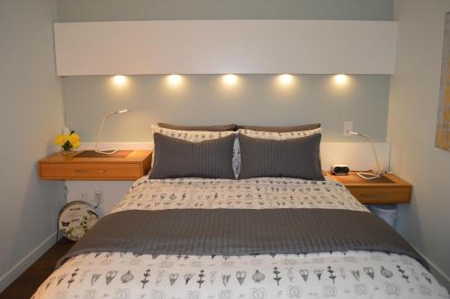 维多利亚海港微风公寓的一间卧室配有一张带2个床头柜和2盏灯的床。