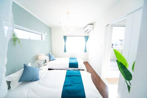 淡路Shizukinosato TSUKI Terrace 531的一间卧室配有两张带蓝白色床单的床