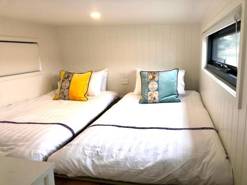 LochielPink Lake Tiny House - 'Peony'的拖车小房间内的两张床