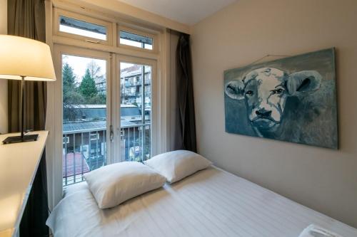 阿姆斯特丹Two-bedroom Apartment in Amsterdam West的卧室配有一张带牛照片的床