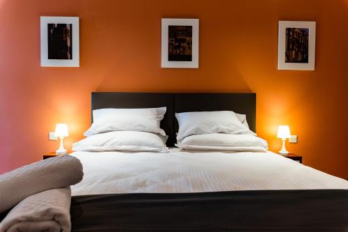 佩奥拉Monreal Boutique Townhouse - R024RM2的一间卧室配有一张带两个枕头和两个灯的床。