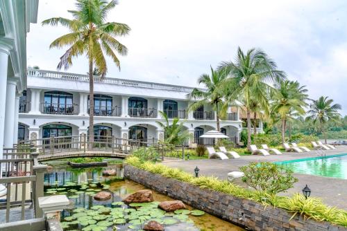 蓬蒂切里Lagoon Sarovar Premiere Resort - Pondicherry的前面有池塘的建筑